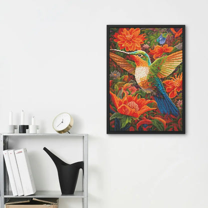 Ingelijste diamond painting van een kolibrie met oranje bloemen aan de muur